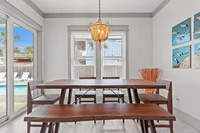 a dining room with a table and chairs and a chandelier at Keep Calm & Pool On at Peaceful Easy Feeling! Sleeps 20! in Panama City Beach