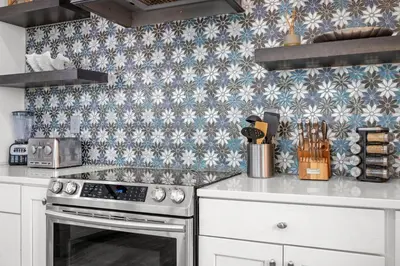 a kitchen with white cabinets and blue and white tiles at Keep Calm & Pool On at Peaceful Easy Feeling! Sleeps 20! in Panama City Beach