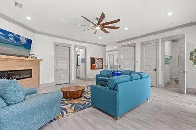 a living room with two blue couches and a fireplace at Keep Calm & Pool On at Peaceful Easy Feeling! Sleeps 20! in Panama City Beach