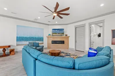 a blue couch in a living room with a fireplace at Keep Calm & Pool On at Peaceful Easy Feeling! Sleeps 20! in Panama City Beach