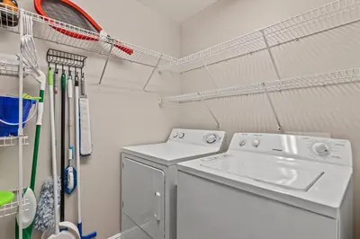 a laundry room with a washing machine and a sink at Splash, Relax & Repeat at Dolphin View Retreat! Beachfront! Sleeps 9! in Panama City Beach