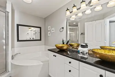 a bathroom with two sinks and a toilet and a tub at Splash, Relax & Repeat at Dolphin View Retreat! Beachfront! Sleeps 9! in Panama City Beach