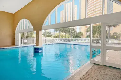 a large swimming pool in a building with windows at Splash, Relax & Repeat at Dolphin View Retreat! Beachfront! Sleeps 9! in Panama City Beach