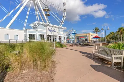 a large ferris wheel in a park with a bench at Come enjoy some Seawaves! 2BR 25BA Sleeps 8! Coastal Townhome w/Beachview! in Panama City Beach