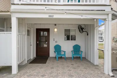 two blue chairs sitting on the front porch of a house at Come enjoy some Seawaves! 2BR 25BA Sleeps 8! Coastal Townhome w/Beachview! in Panama City Beach