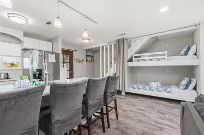 a dining room with a bar with chairs and a bunk bed at Come enjoy some Seawaves! 2BR 25BA Sleeps 8! Coastal Townhome w/Beachview! in Panama City Beach