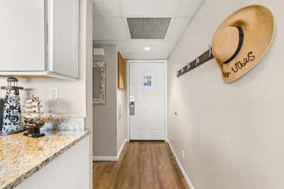 a kitchen with a counter and a hallway at Beachfront! Balcony Views! Pools and Beach Access in Panama City Beach