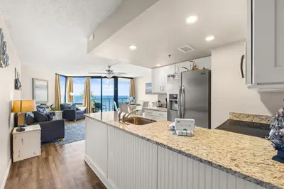 a kitchen and living room with a counter top at Beachfront! Balcony Views! Pools and Beach Access in Panama City Beach