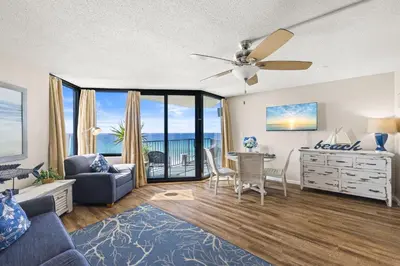 a living room with a couch and a table with a desk at Beachfront! Balcony Views! Pools and Beach Access in Panama City Beach