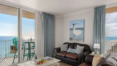 a living room with a couch and a view of the ocean at Tidewater Horizon by Avantstay Beachfront Condo Indoor Pool Spa Amenities Movie Theater Near Pier Park in Panama City Beach