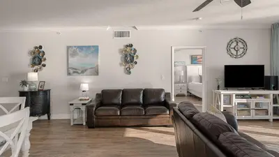 a living room with a couch and a television at Tidewater Horizon by Avantstay Beachfront Condo Indoor Pool Spa Amenities Movie Theater Near Pier Park in Panama City Beach