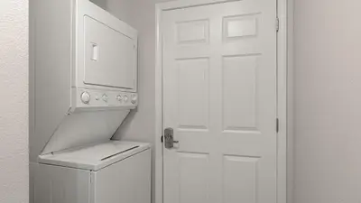 a kitchen with a white door and a white refrigerator at Tidewater Horizon by Avantstay Beachfront Condo Indoor Pool Spa Amenities Movie Theater Near Pier Park in Panama City Beach