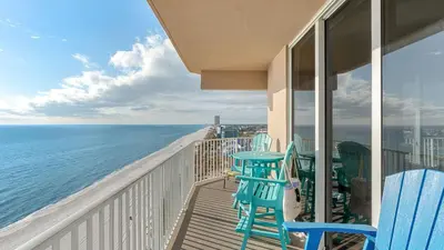 a balcony with chairs and a table and the ocean at Tidewater Horizon by Avantstay Beachfront Condo Indoor Pool Spa Amenities Movie Theater Near Pier Park in Panama City Beach