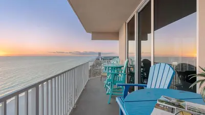 a balcony with tables and chairs overlooking the ocean at Tidewater Horizon by Avantstay Beachfront Condo Indoor Pool Spa Amenities Movie Theater Near Pier Park in Panama City Beach