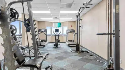 a gym with several tread machines in a room at Tidewater Horizon by Avantstay Beachfront Condo Indoor Pool Spa Amenities Movie Theater Near Pier Park in Panama City Beach