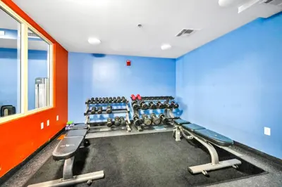 a gym with blue walls and rows of weights at Shores of Panama 530 in Panama City Beach