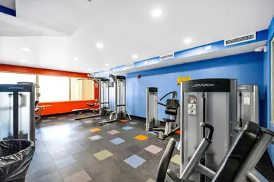 a gym with cardio equipment and a blue wall at Shores of Panama 530 in Panama City Beach