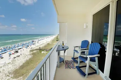 a balcony with two blue chairs and the beach at Shores of Panama 530 in Panama City Beach