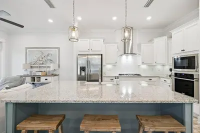 a kitchen with a large island with two stools at TL SEA 88 Pine Lands Loop W Unit A in Inlet Beach