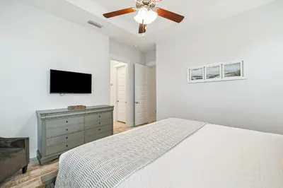 a bedroom with a bed and a flat screen tv at TL SEA 88 Pine Lands Loop W Unit A in Inlet Beach