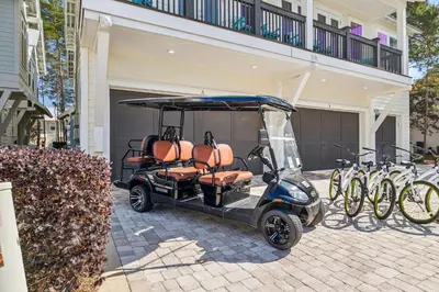 a golf cart parked in front of a building with bikes at TL SEA 88 Pine Lands Loop W Unit A in Inlet Beach