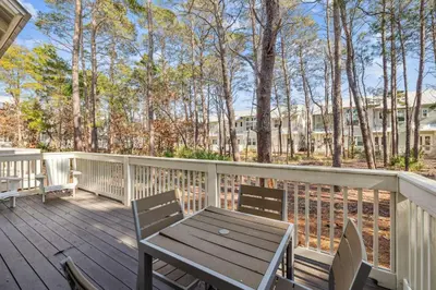 a wooden deck with a wooden table and chairs at TL SEA 88 Pine Lands Loop W Unit A in Inlet Beach
