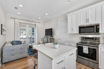 a kitchen with white cabinets and a living room at BAH Casa in Inlet Beach