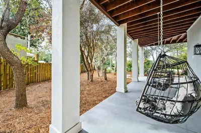 a bird swing hanging from the porch of a house at Where Waters Meet by Travel Life Vacations in Watersound Beach