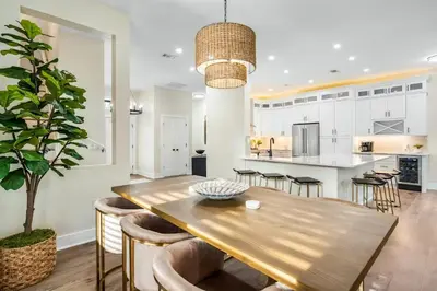 a kitchen and dining room with a wooden table and chairs at Where Waters Meet by Travel Life Vacations in Watersound Beach