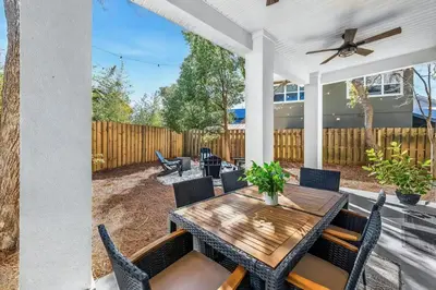 a patio with a wooden table and chairs at Where Waters Meet by Travel Life Vacations in Watersound Beach