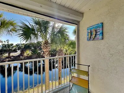 a balcony with a view of the ocean and palm trees at Horizon South 59-202 in Panama City Beach