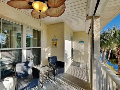 a porch with a ceiling fan and a table and chairs at Horizon South 59-202 in Panama City Beach