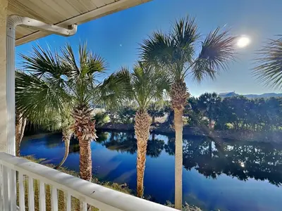a view of a river from a balcony with palm trees at Horizon South 59-202 in Panama City Beach