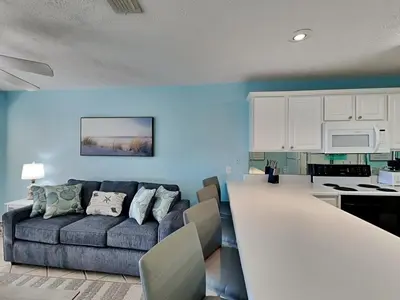 a living room with a couch and a kitchen at Horizon South 59-202 in Panama City Beach