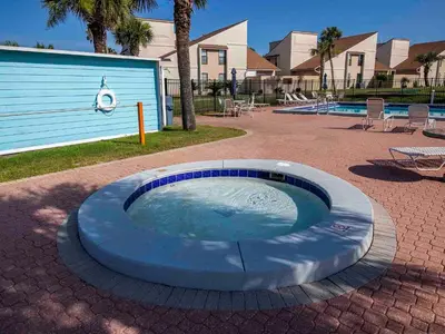 a circular pool in a patio with chairs and a building at Horizon South 59-202 in Panama City Beach
