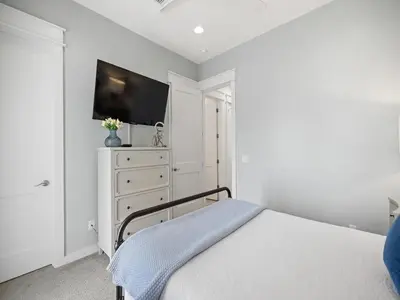 a bedroom with a bed and a dresser with a tv at Sugar Sands in Panama City Beach