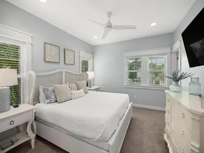 a bedroom with a white bed and two windows at Sugar Sands in Panama City Beach