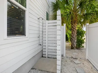 a white house with a staircase next to a palm tree at Sugar Sands in Panama City Beach