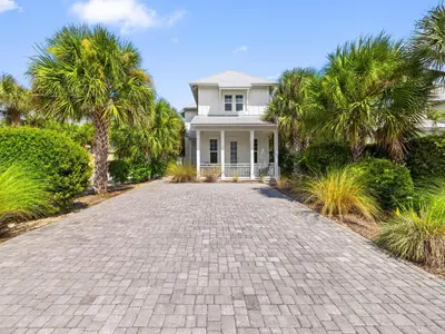 a white house with palm trees and a driveway at Sugar Sands in Panama City Beach