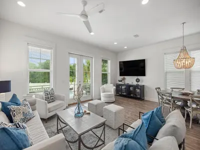a living room with white furniture and a table at Sugar Sands in Panama City Beach