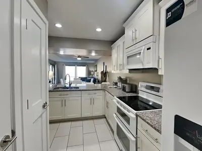 a kitchen with white cabinets and a sink at Edgewater Villa #1902 in Panama City Beach