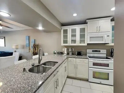 a kitchen with white cabinets and a sink at Edgewater Villa #1902 in Panama City Beach