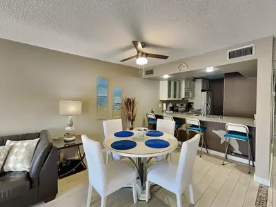 a living room with a table and chairs and a kitchen at Edgewater Villa #1902 in Panama City Beach