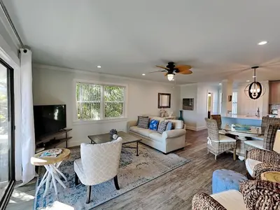 a living room with a couch and a tv at Cassine Gardens #101 in Seagrove Beach