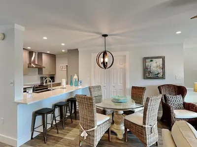 a kitchen and living room with a table and chairs at Cassine Gardens #101 in Seagrove Beach