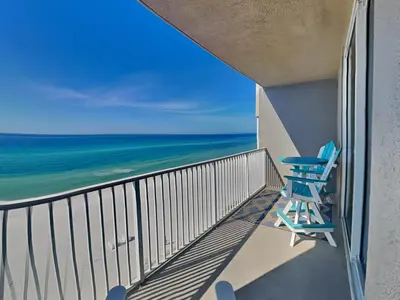 a balcony with a blue chair and the ocean at Tidewater Beach Resort #503 in Panama City Beach