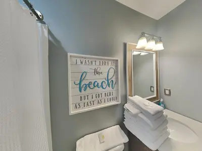 a bathroom with a toilet and a mirror and towels at Tidewater Beach Resort #503 in Panama City Beach