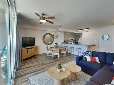 a living room with a blue couch and a table at Tidewater Beach Resort #503 in Panama City Beach