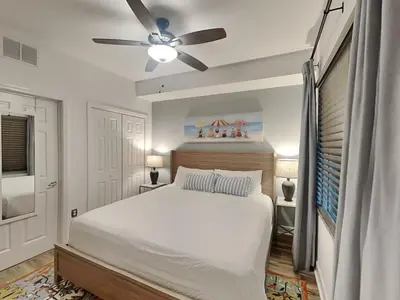 a bedroom with a white bed and a ceiling fan at Tidewater Beach Resort #503 in Panama City Beach
