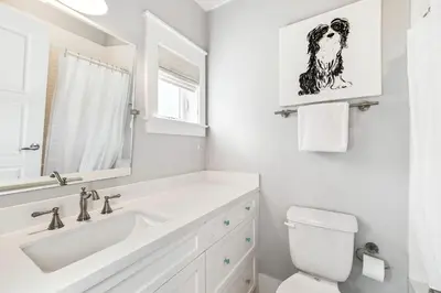 a white bathroom with a sink and a toilet at Casablanca By The Sea by 30A Escapes in Rosemary Beach